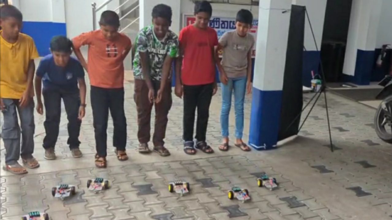 Students watching their robots race across the floor