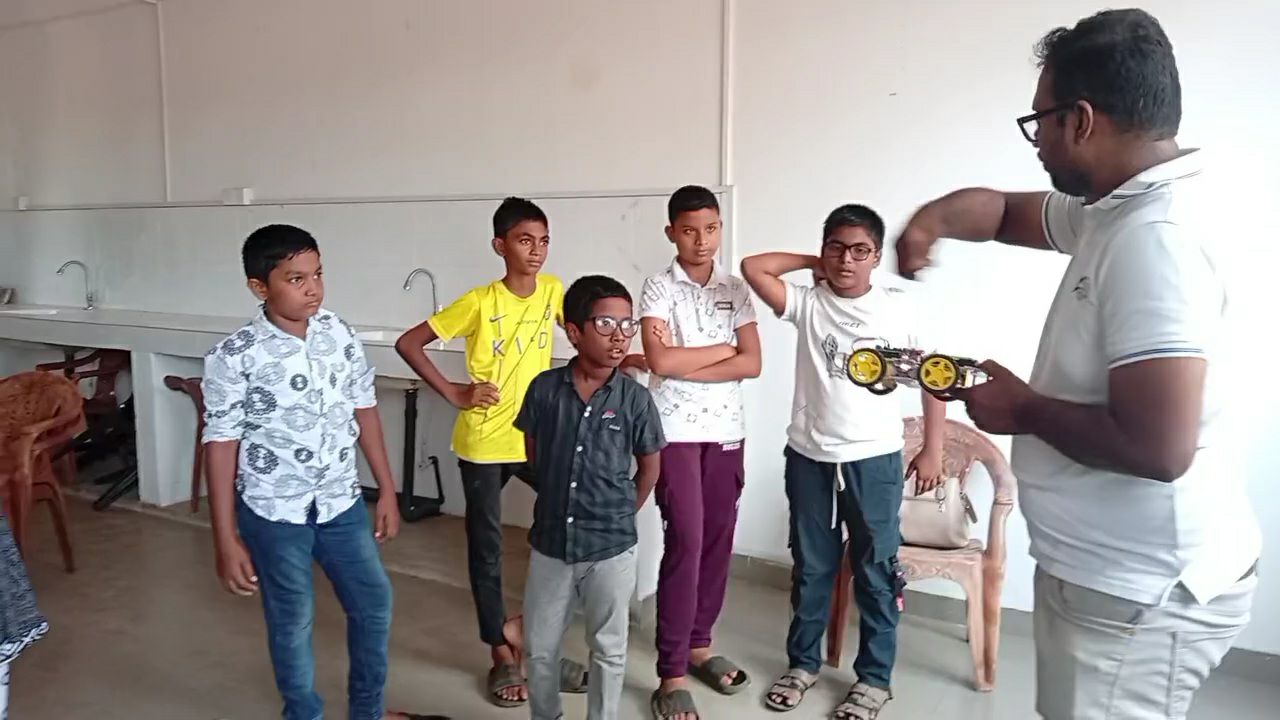 A mentor showing students a robot in Thihariya